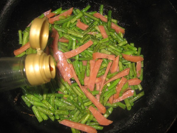 倒入切好的火腿和豆角翻炒5.锅里放油,放入葱花炝锅4.葱切片备用3.
